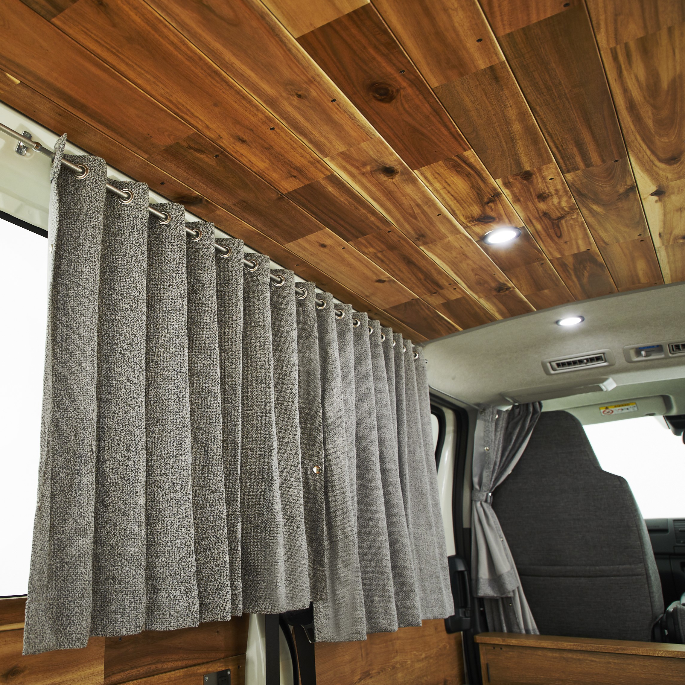 天井も無垢材で覆われ、特徴的なダウンライトを配置。カーテンで車中泊時のプライバシーも確保